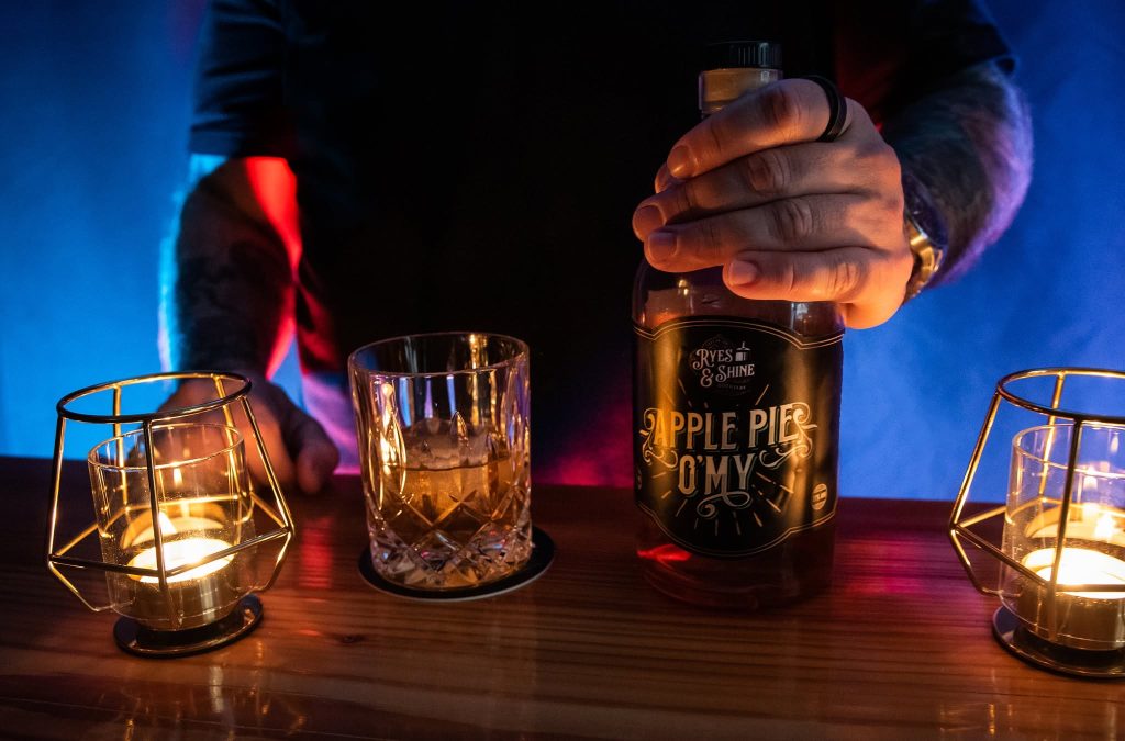 Apple Pie O’My poured beside candlelit glasses at the bar