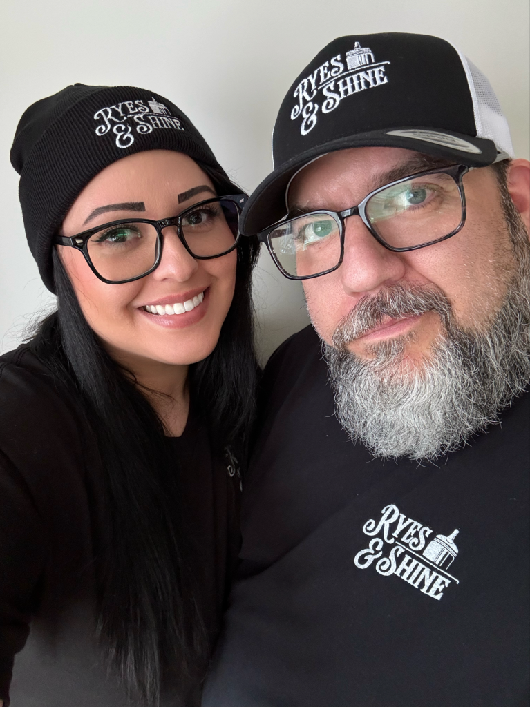 Two members of the Ryes & Shine team wearing branded hats
