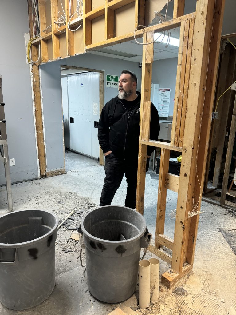 A team member in the distillery space during renovation